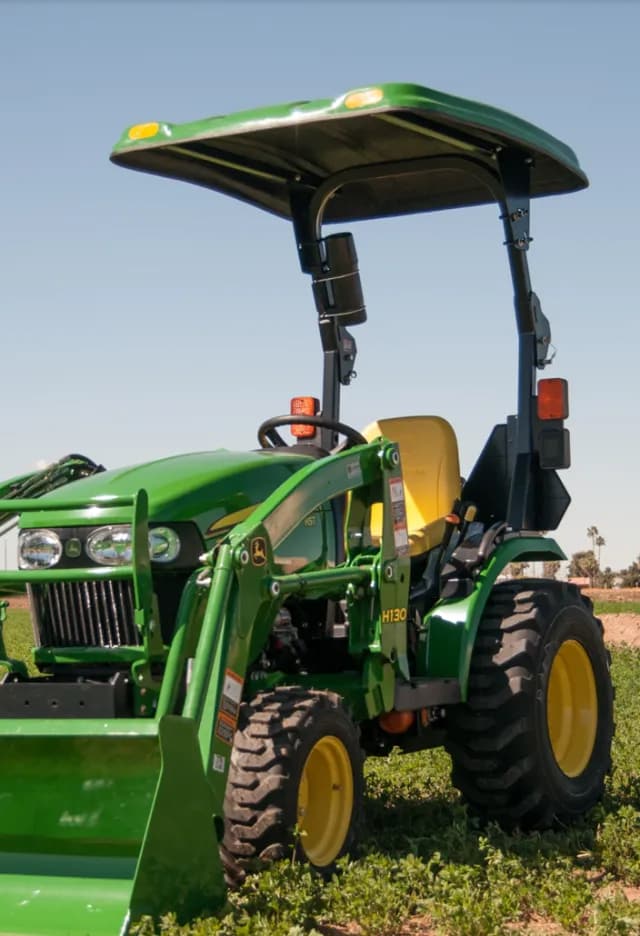 Green compact tractor with a fiberglass sunshade canopy