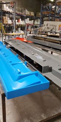 Long blue fiberglass part in the production shop