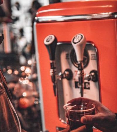 Drink being poured from the tap of a red replica gas pump